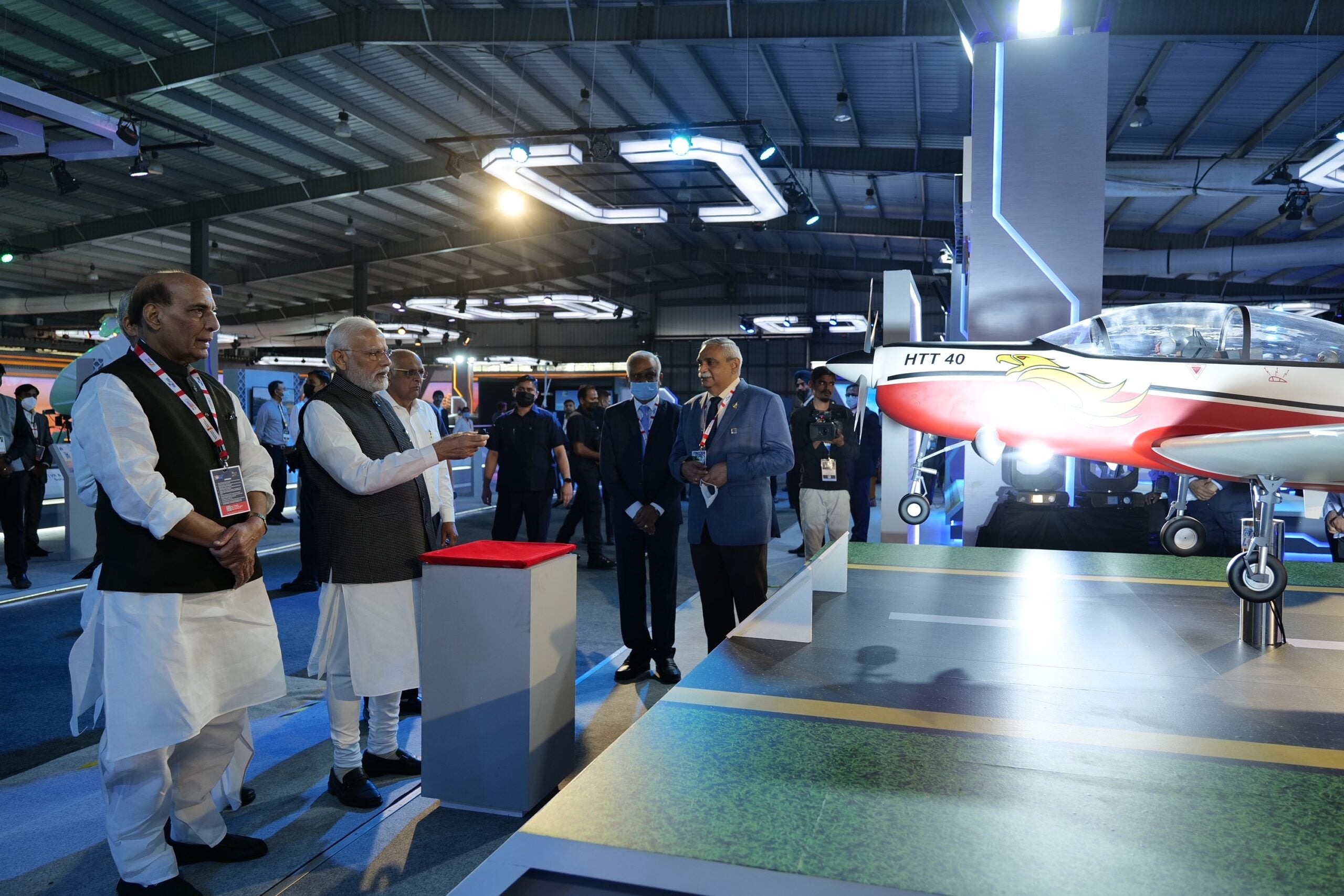 HAL HTT-40 aircraft displayed indoors with officials nearby
