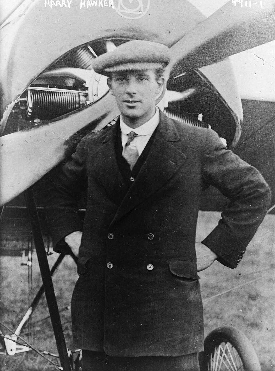 Portrait of Harry Hawker standing beside an aircraft, showing the aviator whose name became attached to Hawker Aircraft.