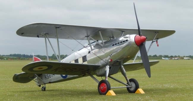 Silver Hawker Fury K5674 parked on grass with RAF roundel and red wheels.