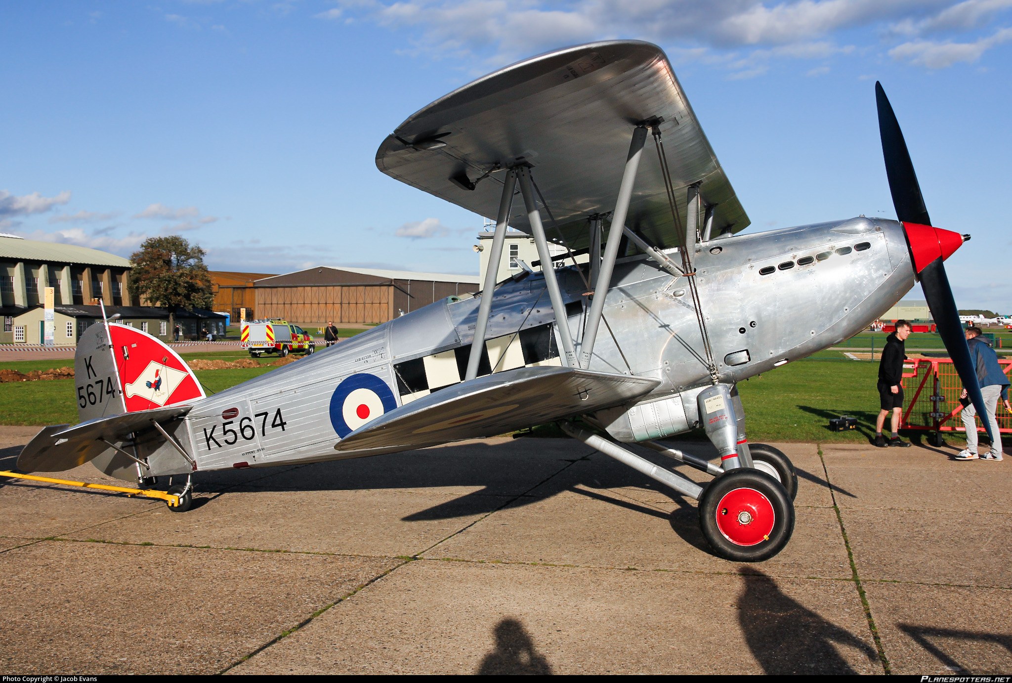 Close side view of silver Hawker Fury K5674 on a paved airfield apron.