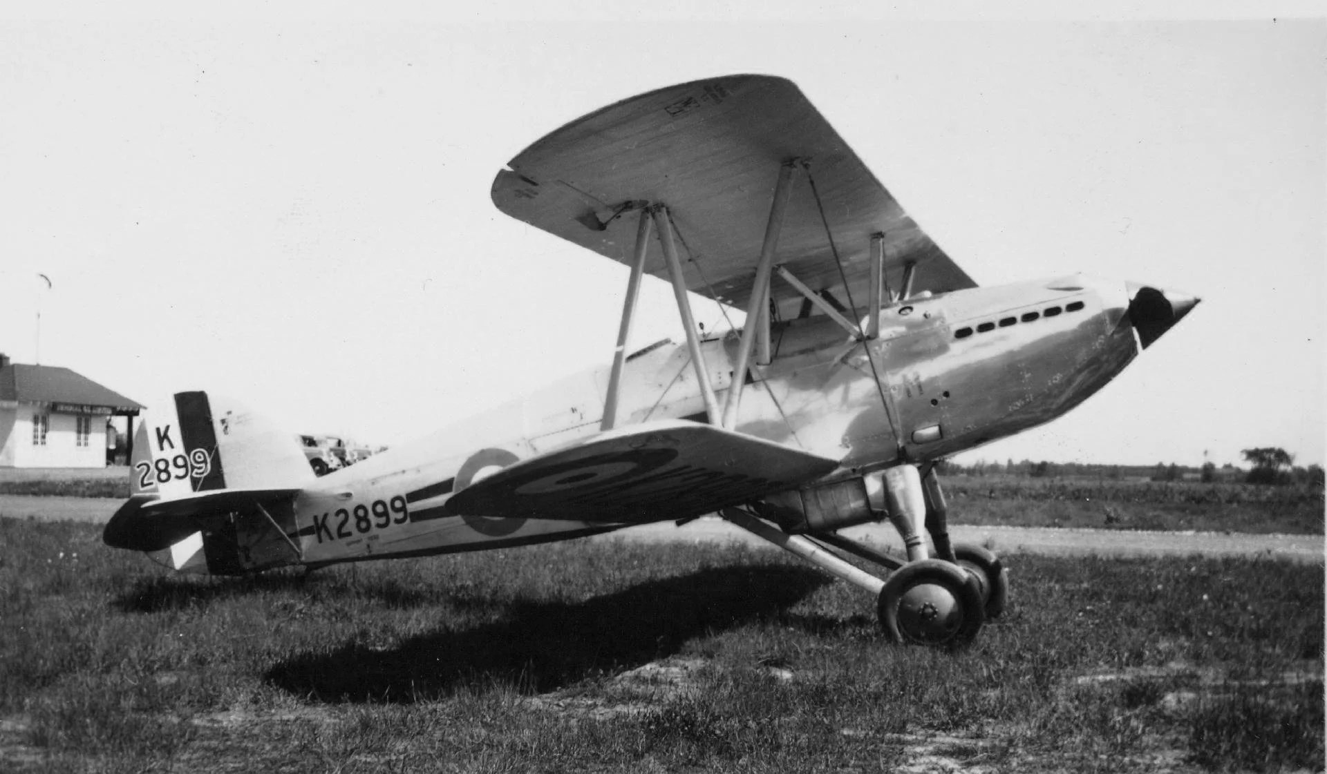 Black-and-white side view of Hawker Fury K2899 parked on grass.