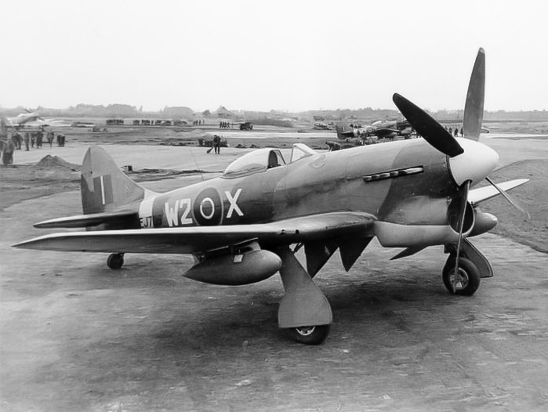 Black-and-white side view of Hawker Tempest marked W2-X parked on an airfield.