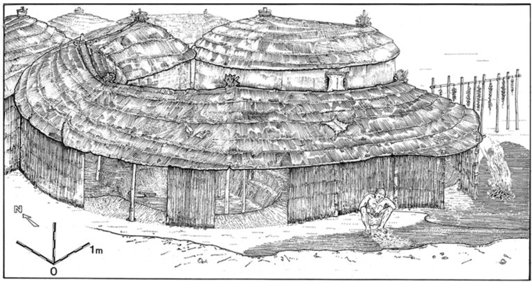 Reconstruction of phase 1A pit dwellings showing a person seated on the open bench area in the foreground. Abu Hureyra, Syria