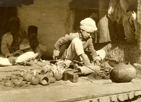 A boy making bangles from coconut shells at a Bangle factory in India