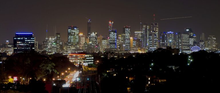 Brisbane skyline above a dark rail corridor