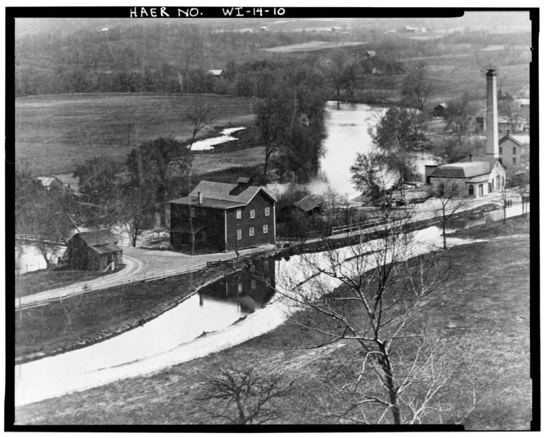 Photocopy of photograph . Photographer and date unknown VIEW TO SOUTHEAST. BRIDGE TO LEFT. MANCHESTER ROLLER MILL AND CITY PUMPING STATION AT LEFT CENTER AND RIGHT. Manchester Street Bridge, Spanning Baraboo River on Manchester Street, Baraboo, Sauk County, WI