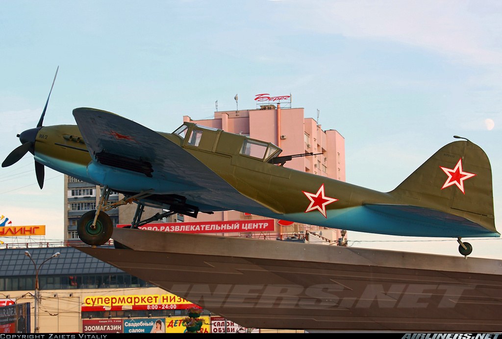Green Ilyushin Il-2 number 17 displayed outdoors on a raised platform.