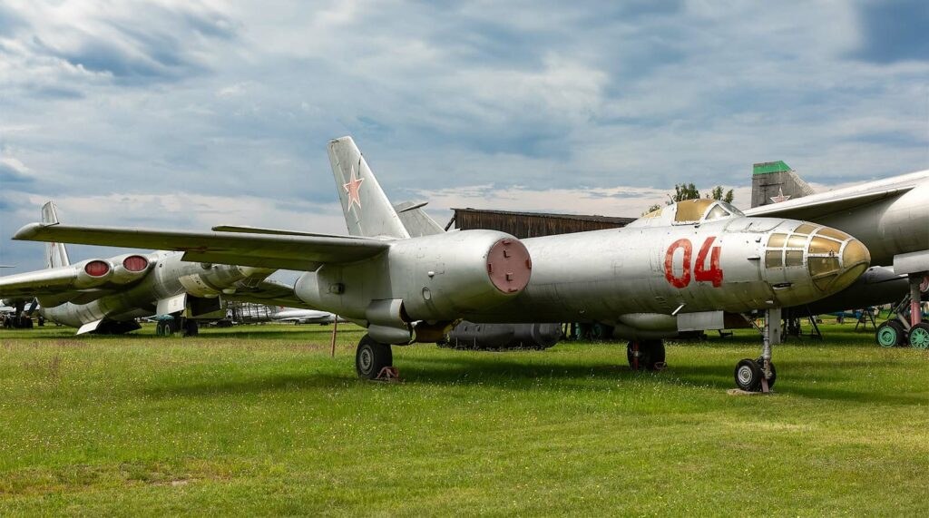 Grey Ilyushin Il-28 marked red 04 parked outdoors with red star tail marking.