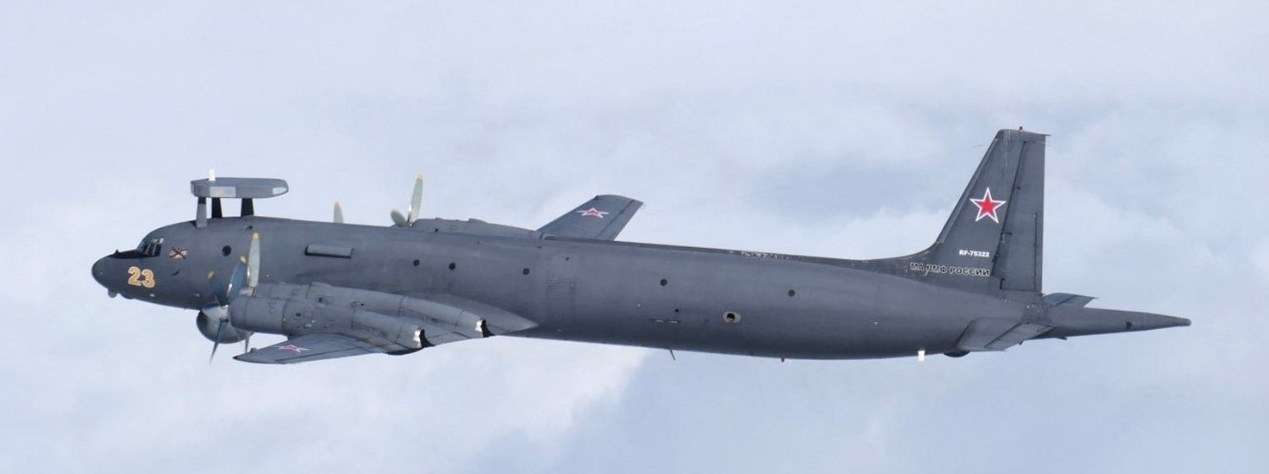 Dark grey Russian Ilyushin Il-38N marked red 23 flying with dorsal radar fairing.