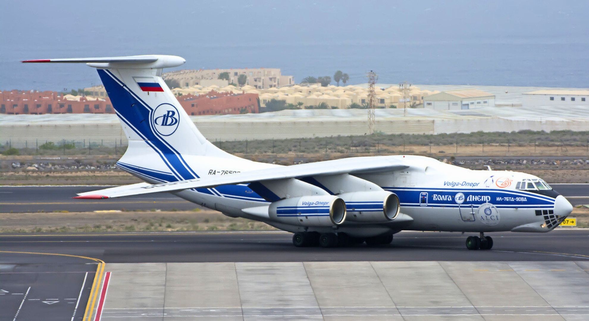 Volga-Dnepr Ilyushin Il-76 moving along a runway with ocean behind it.