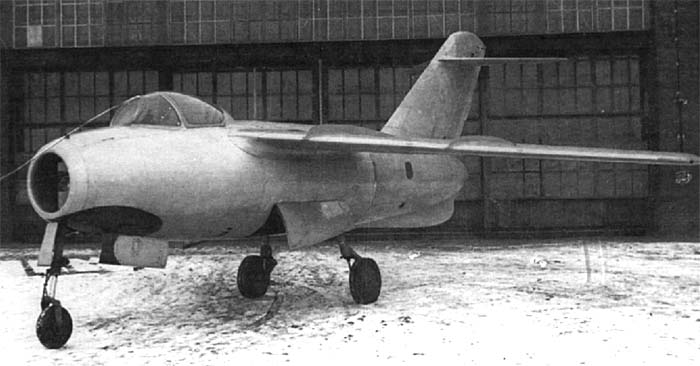 Lavochkin La-15 jet fighter parked in front of a hangar