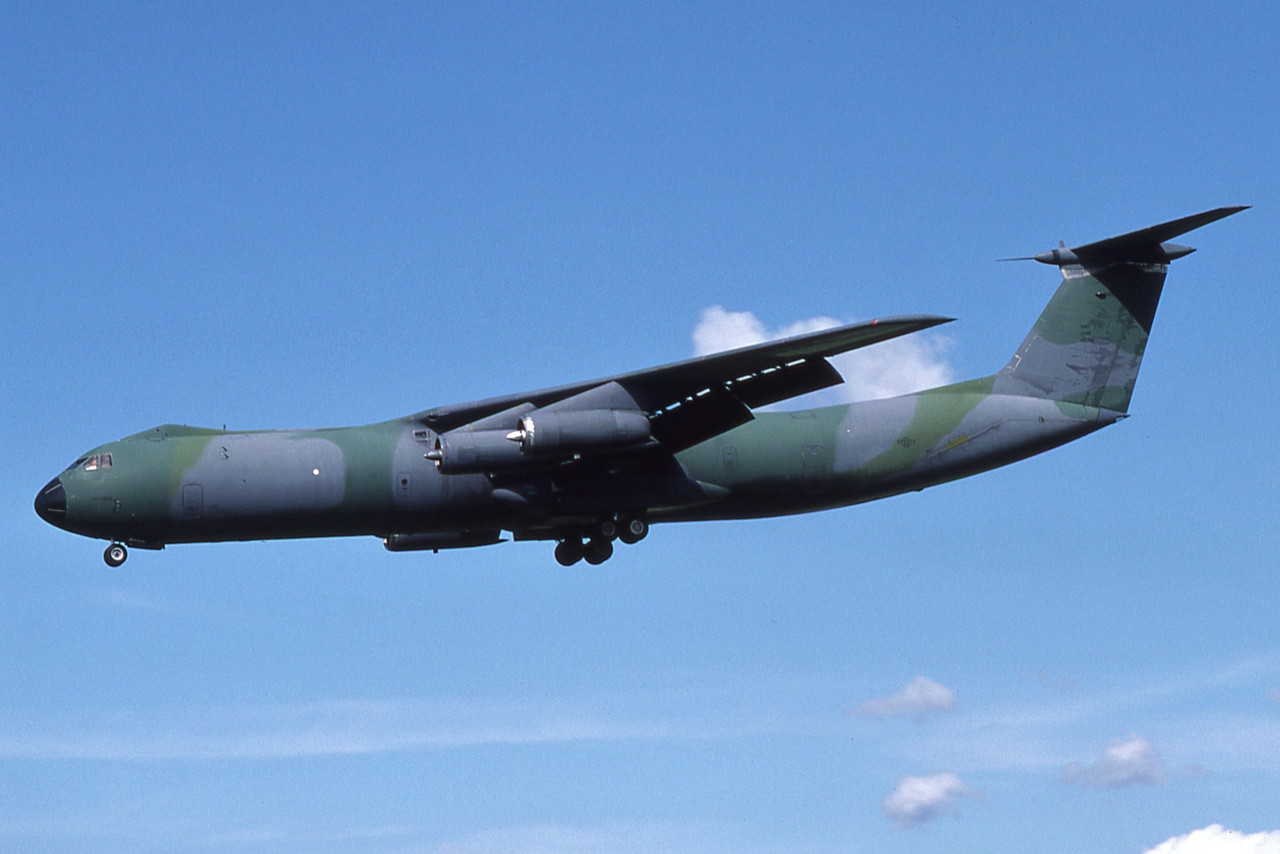 Camouflaged Lockheed C-141 Starlifter flying in side view.