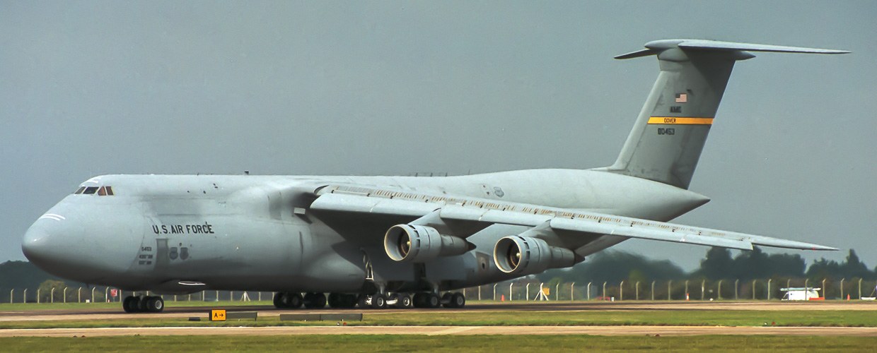 Grey U.S. Air Force C-5 Galaxy on a runway with Dover tail marking.