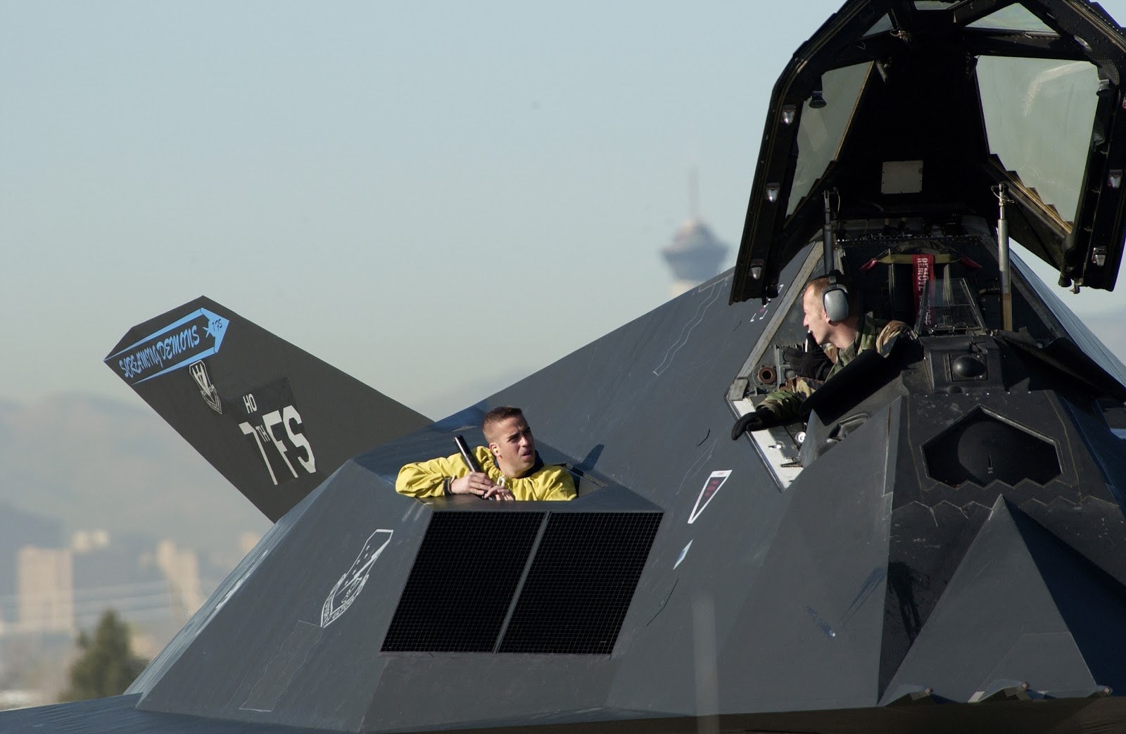 F-117 Nighthawk on a ramp with the cockpit canopy open.