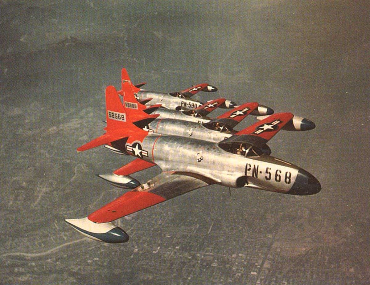 Formation of silver F-80 Shooting Stars with red tails in flight.