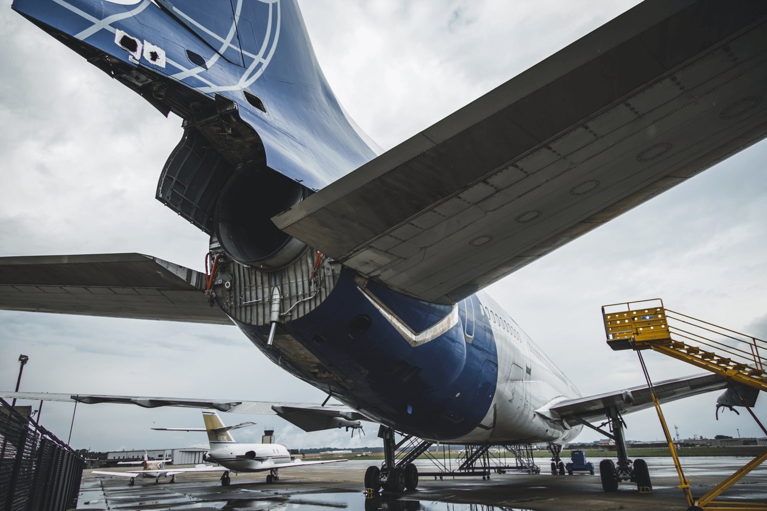Lockheed L-1011 TriStar rear fuselage and tail engine on a wet ramp.
