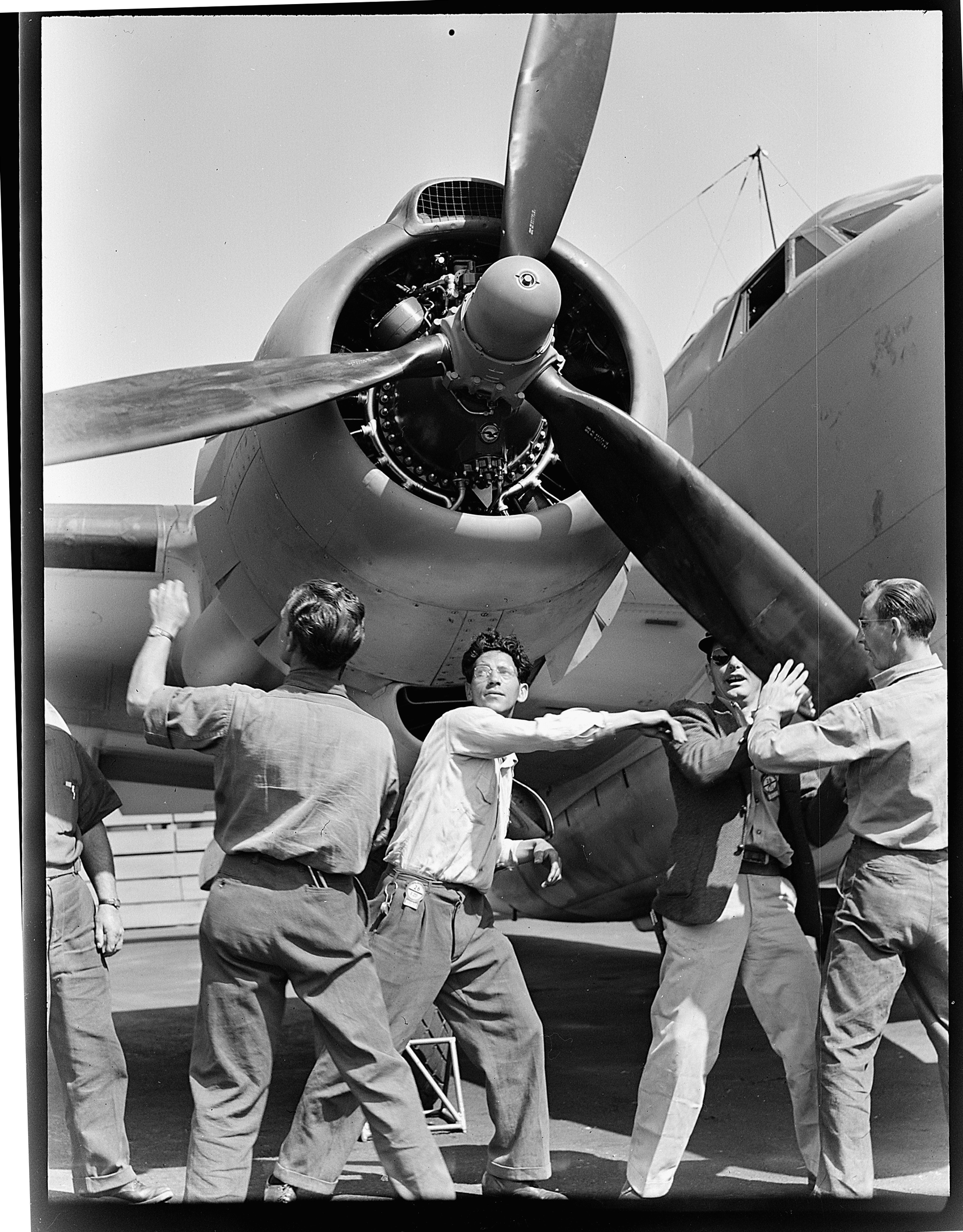 Wartime production scene at the Vega aircraft plant in Burbank, with workers inspecting a Lockheed PV-1 Ventura nose and propeller assembly.