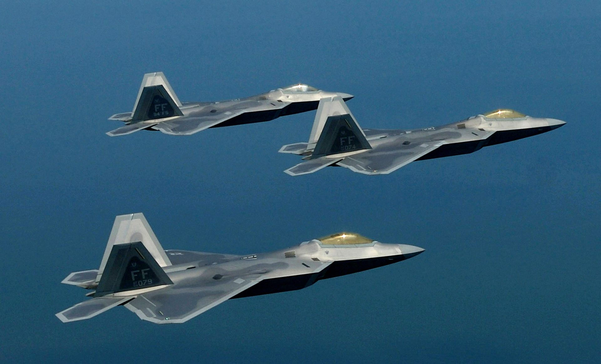 Formation of F-22 Raptors in flight, showing multiple Lockheed Martin stealth fighters operating together.
