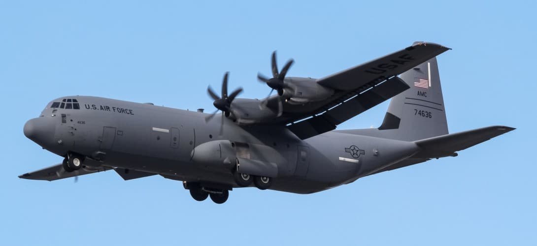 U.S. Air Force C-130J Super Hercules flying side-on with propellers turning.