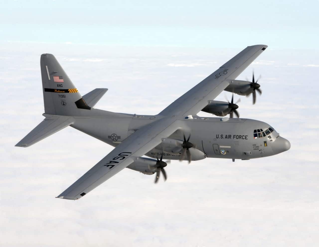 U.S. Air Force C-130J Super Hercules flying above clouds.
