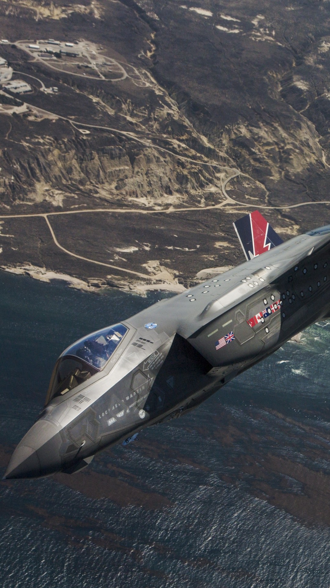 F-35 Lightning II banking above coastline and water.
