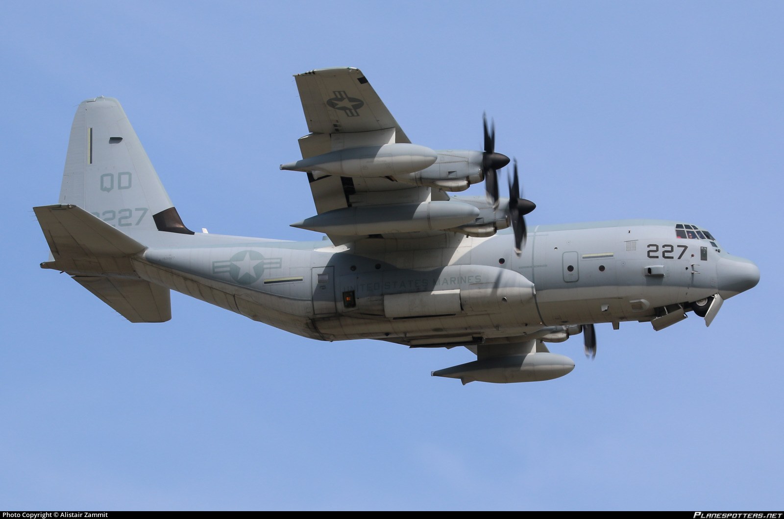 Marine KC-130J 227 flying side-on with propellers turning.