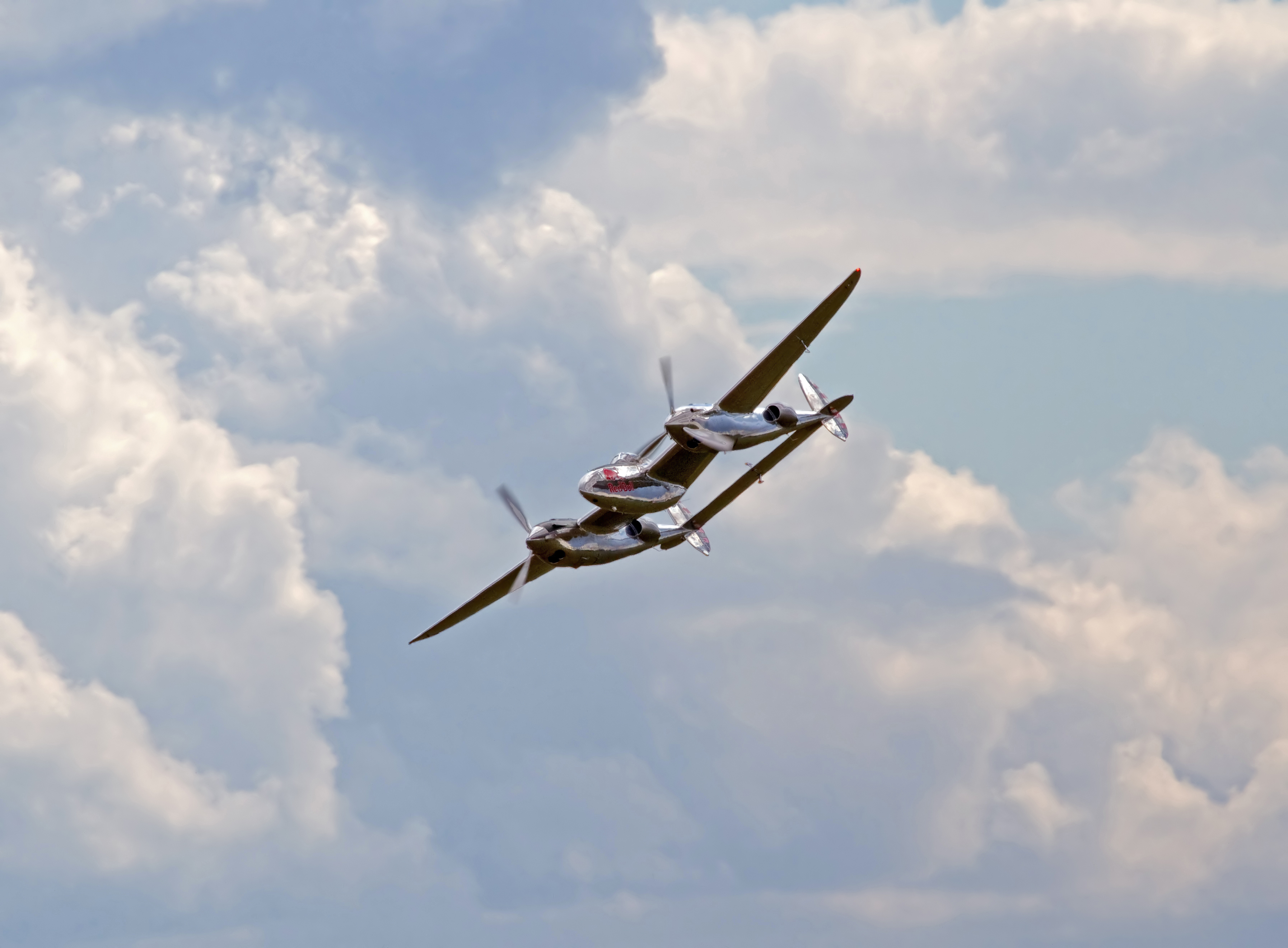 Lockheed P-38 Lightning aircraft in flight, showing the twin-engine fighter in its intended aerial setting.