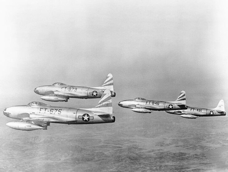 Four P-80 Shooting Stars flying in black-and-white formation.