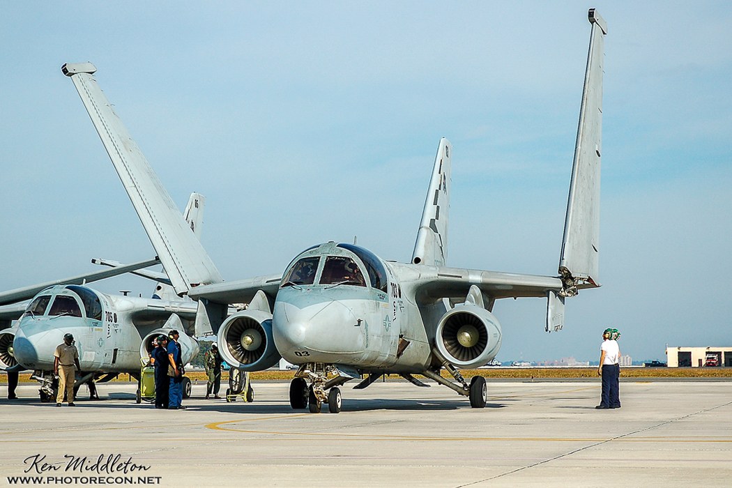 S-3 Viking parked head-on with folded wings and crew nearby.