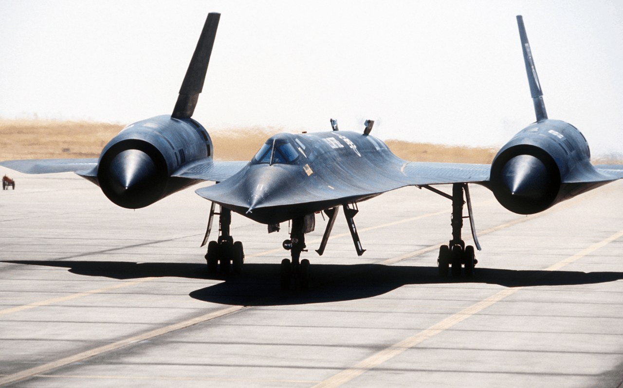 SR-71 Blackbird viewed head-on on a runway with landing gear down.