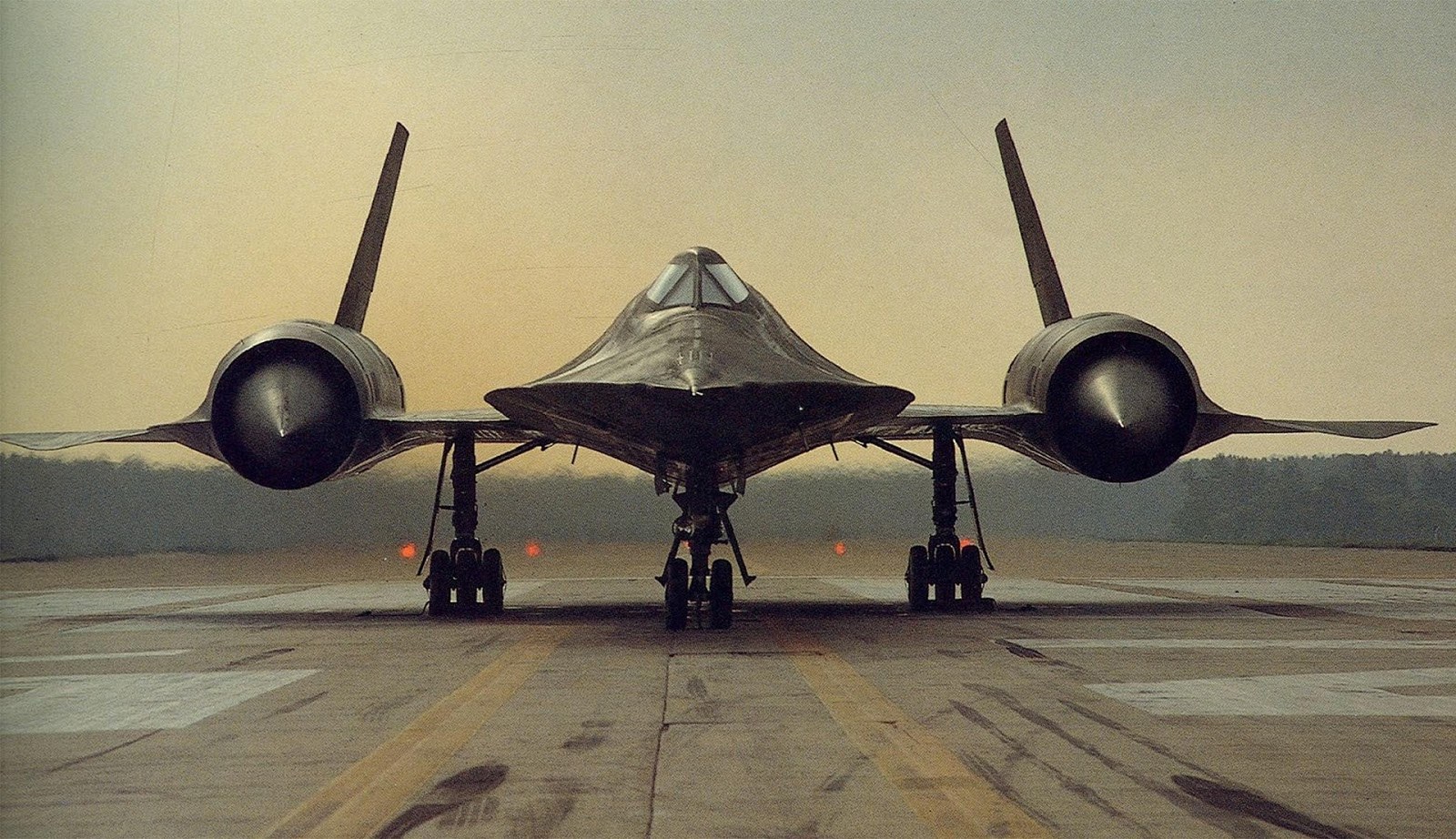 SR-71 Blackbird facing the camera on a runway at dusk.