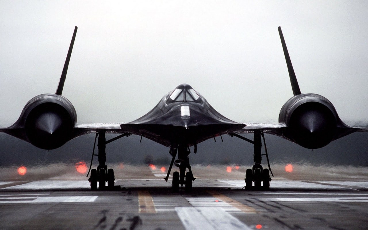 SR-71 Blackbird facing the camera on a wet runway.