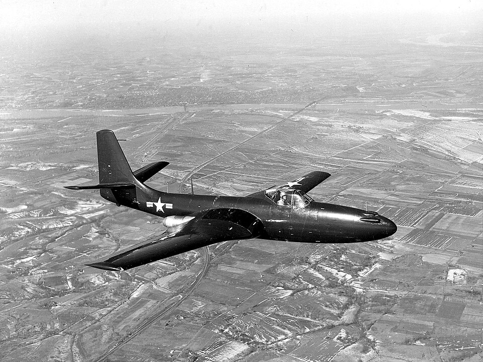 McDonnell FH-1 Phantom in flight over terrain, showing the early jet fighter developed by McDonnell before the McDonnell Douglas merger.
