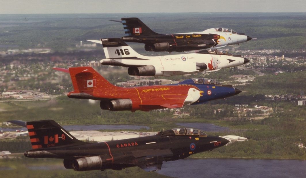 Four Canadian CF-101 Voodoos flying in different commemorative paint schemes.