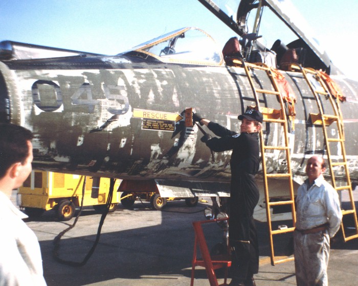 Close view of CF-101 Voodoo 045 with canopy open and people working beside it.