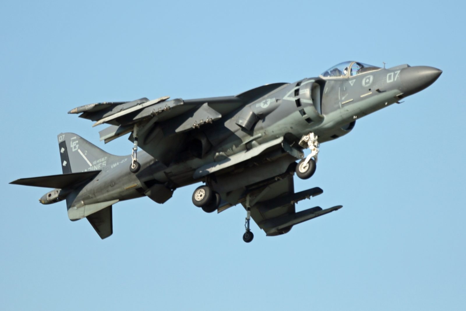 Marine AV-8B Harrier II 66 flying with landing gear down.