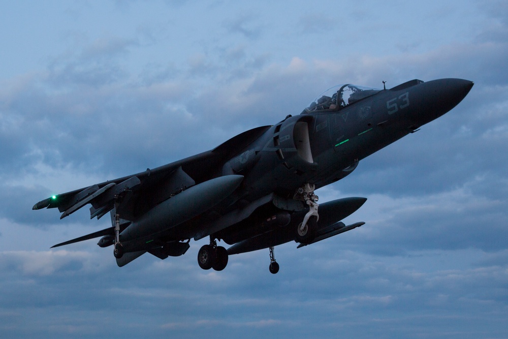 AV-8B Harrier II 55 approaching with landing gear down under cloudy sky.