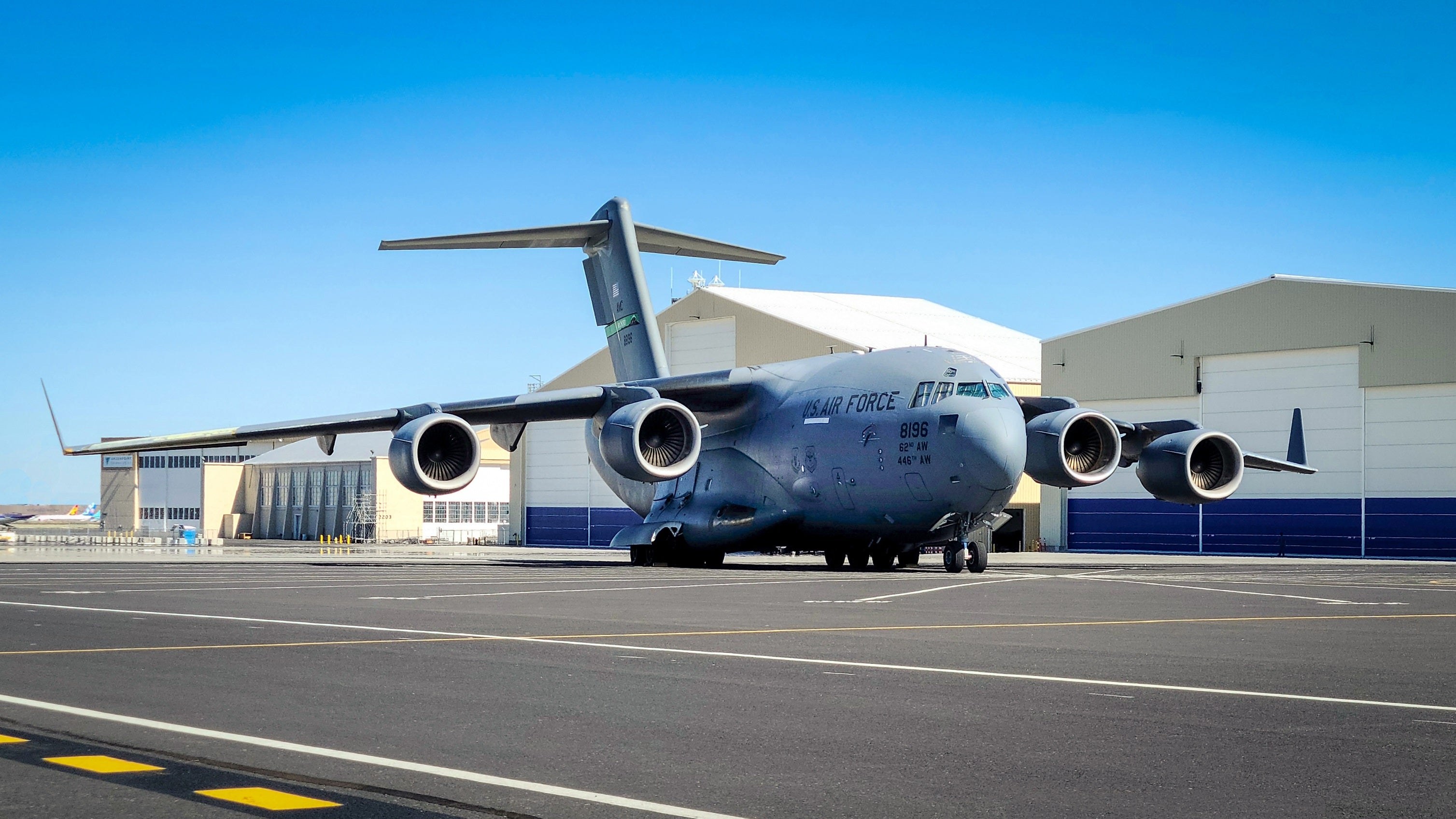 U.S. Air Force C-17 Globemaster III parked on a ramp near hangars.