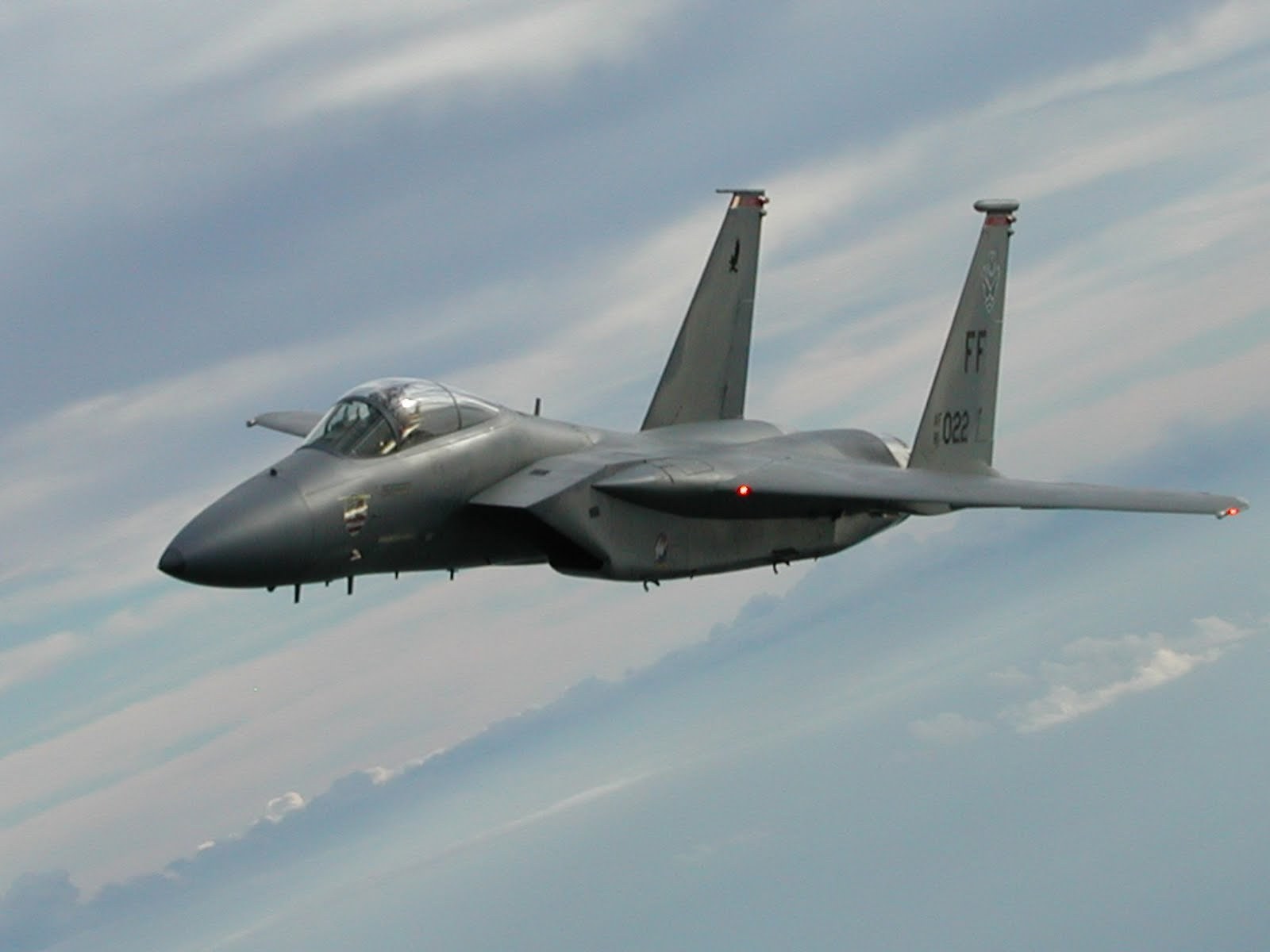 F-15 Eagle FF 1022 flying over clouds in side view.