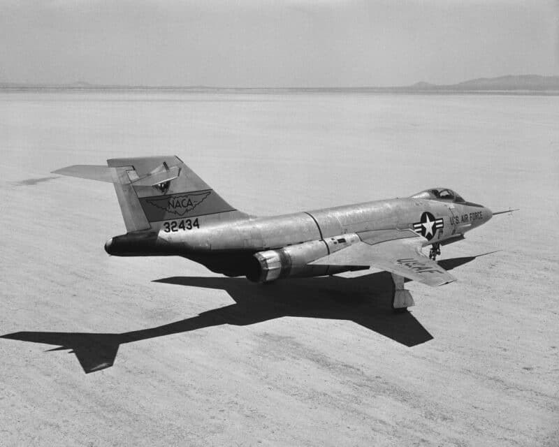 Black-and-white NACA-marked F-101A Voodoo numbered 82434 flying low over a flat dry lakebed.
