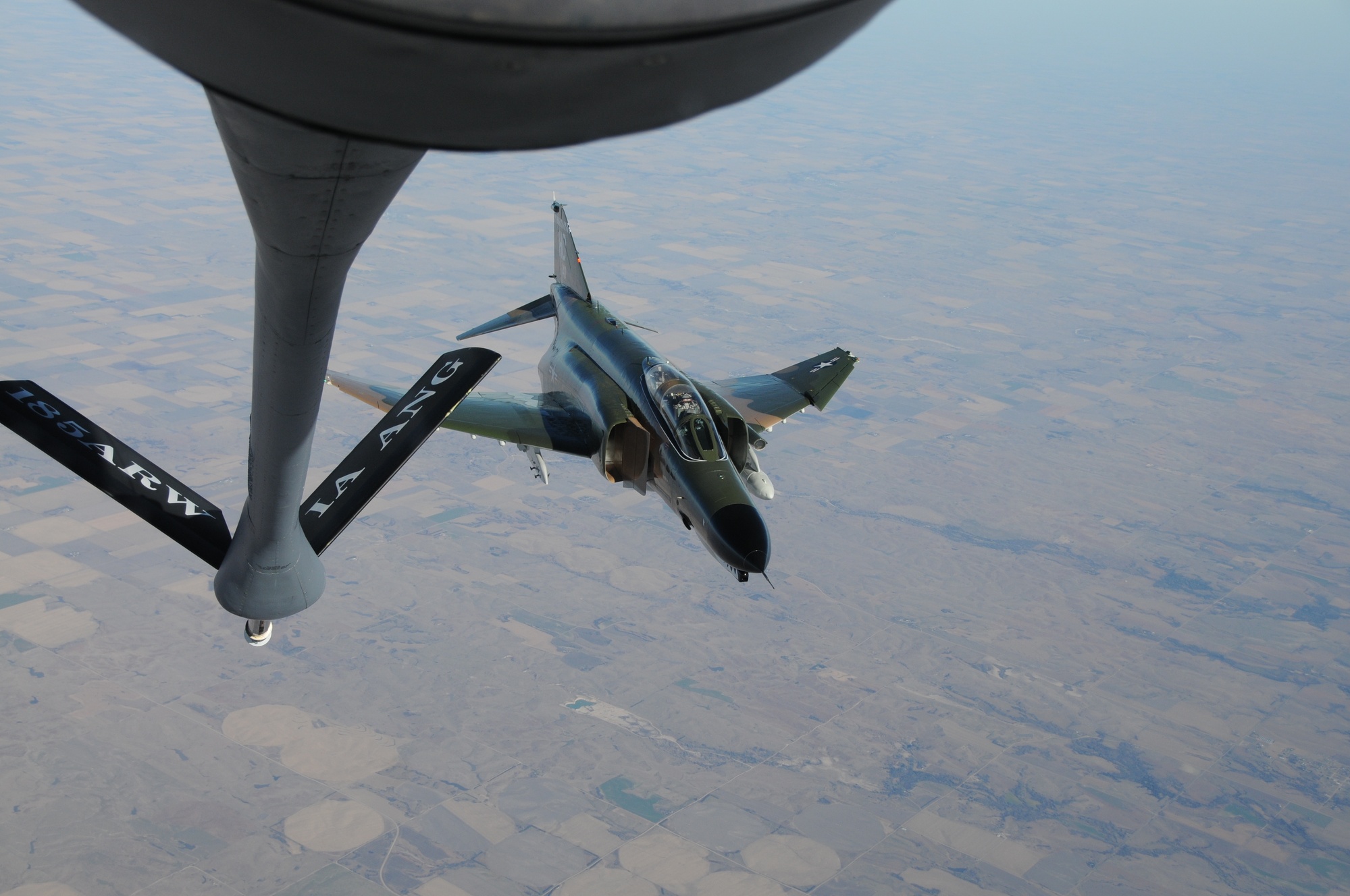 F-4 Phantom II below a tanker boom during aerial refueling.