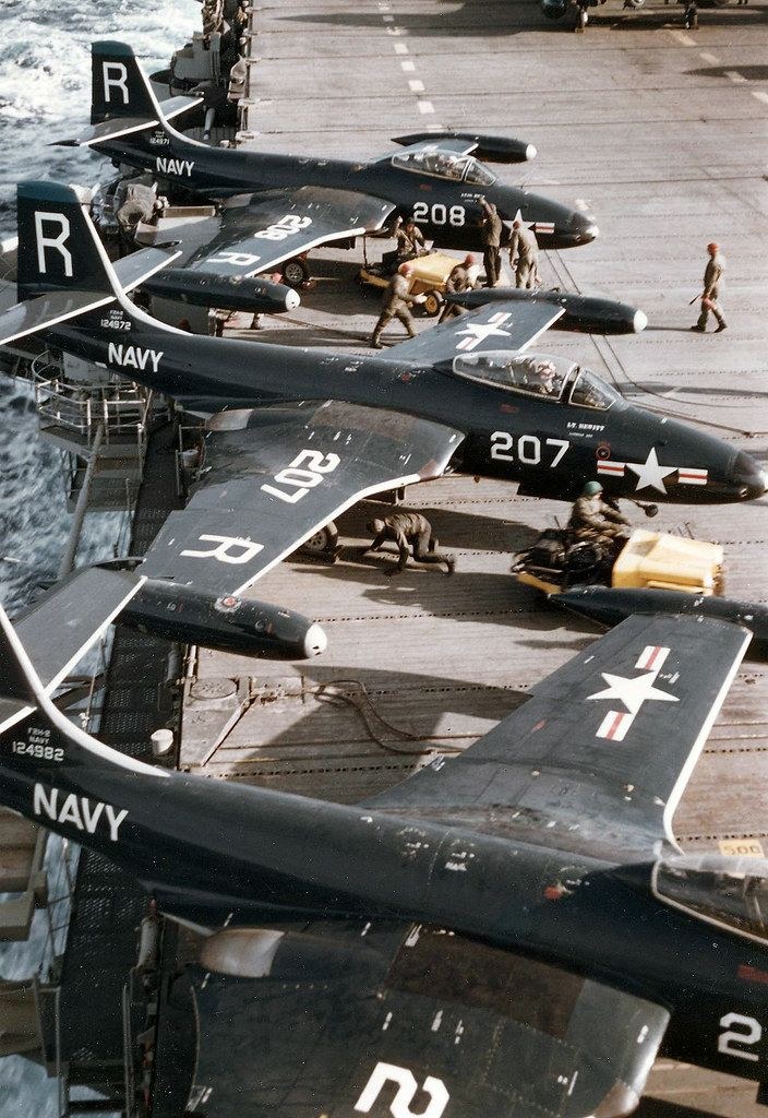 Several U.S. Navy F2H Banshee aircraft parked close together on an aircraft carrier deck.