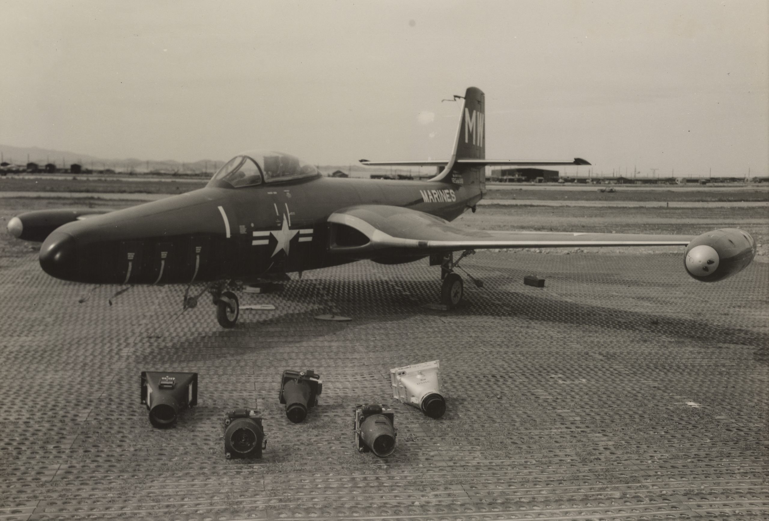 Black-and-white view of a U.S. Navy F2H Banshee parked on a ramp with gear down.