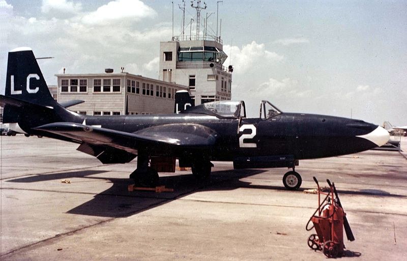 Dark FH Phantom numbered 2 parked on an airfield ramp near a control tower.