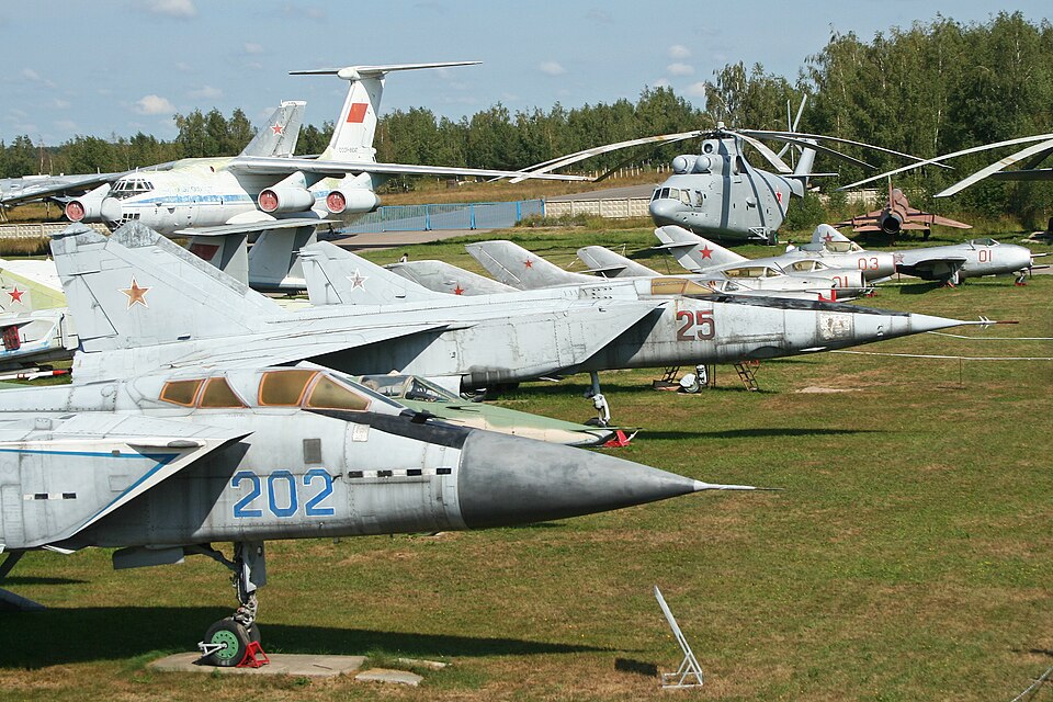 MiG aircraft displayed outdoors at Monino, showing multiple Mikoyan-designed aircraft preserved in a museum setting.