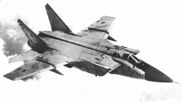 Black-and-white view of a MiG-31 flying with landing gear retracted and red star markings.