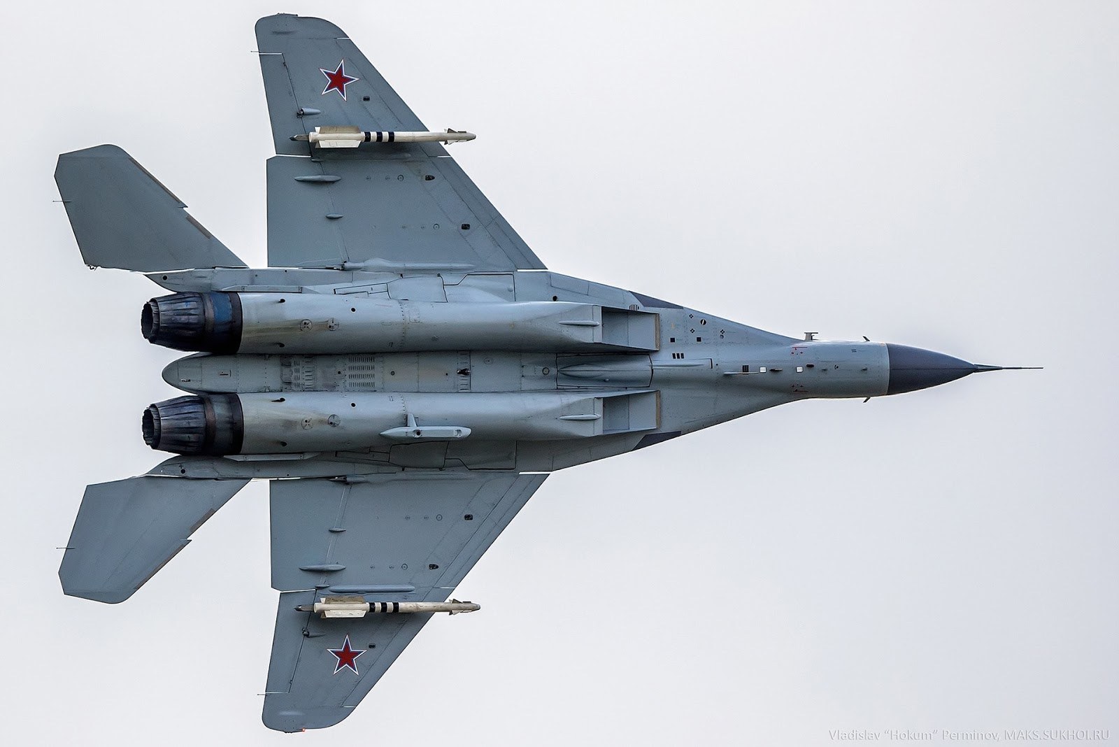 Underside view of a MiG-35 in flight with red star markings and landing gear retracted.