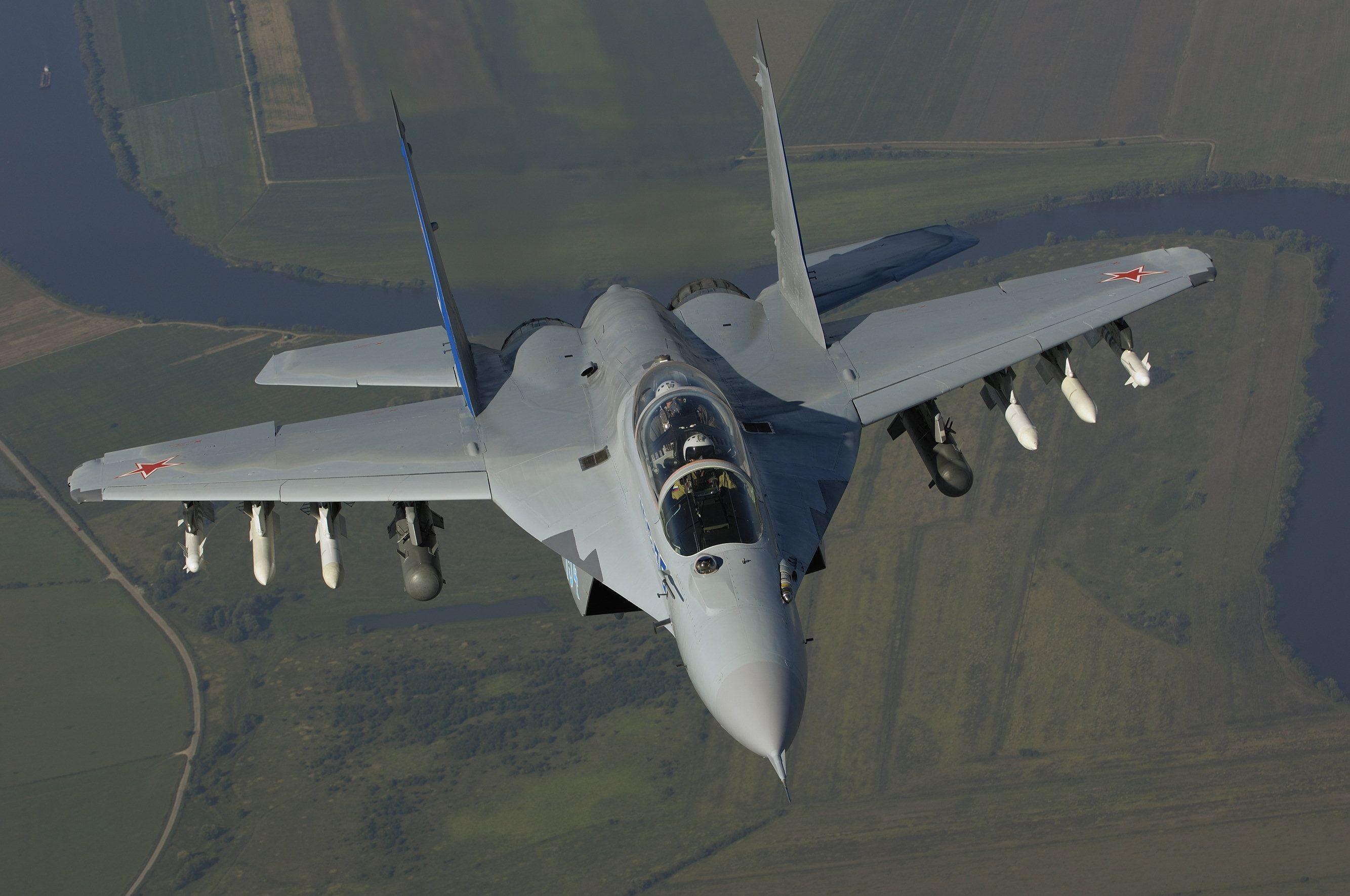 Front-top view of a gray MiG-35 in flight carrying underwing stores.