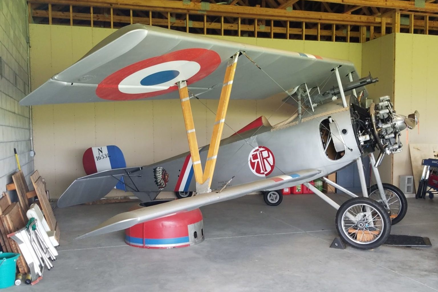French-marked Nieuport 17 displayed indoors with roundels and exposed rotary engine.