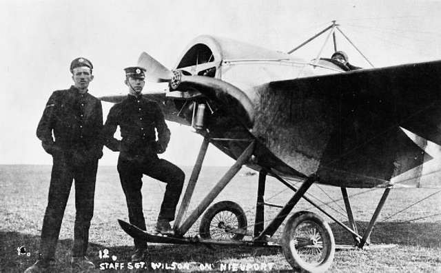 Black-and-white photograph of two uniformed men standing beside a Nieuport IV.